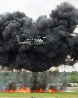 Illustration for article titled Here's an Apache attack helicopter flying away from a monster explosion